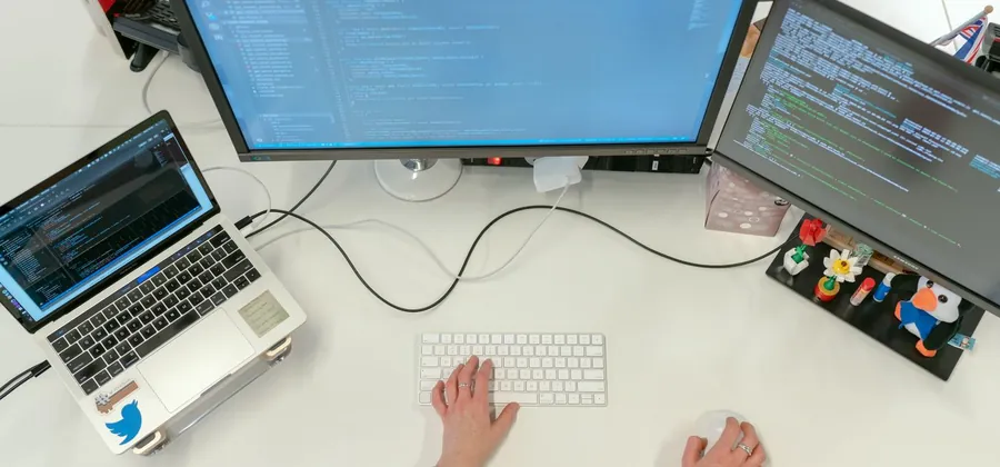 Stock photo: a software workstation with dual monitors and a laptop