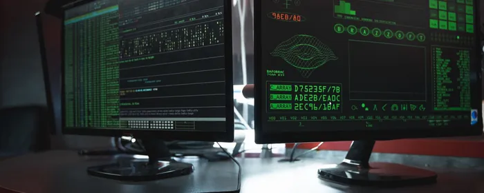Stock photo: monitors showing code in a dark room
